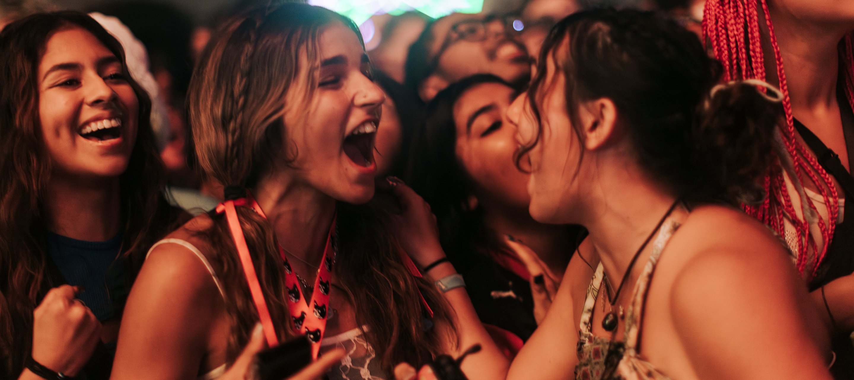 A crowd of fans with hands raised at a live music event.